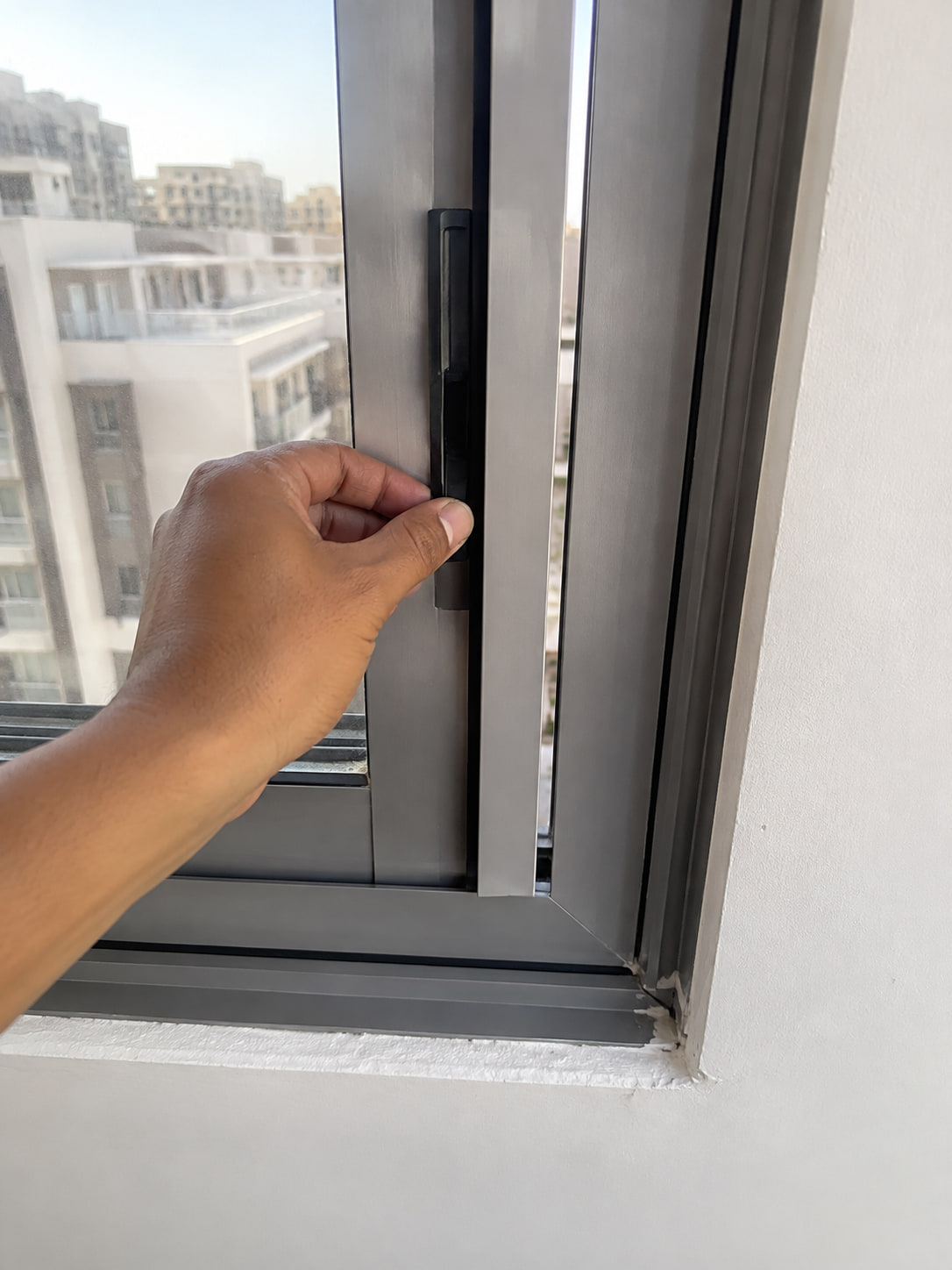 Hand checking the handle and alignment of a sliding aluminium window
