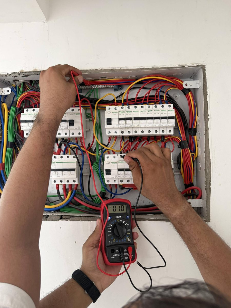 Inspector using a multimeter at an accessible residential distribution board