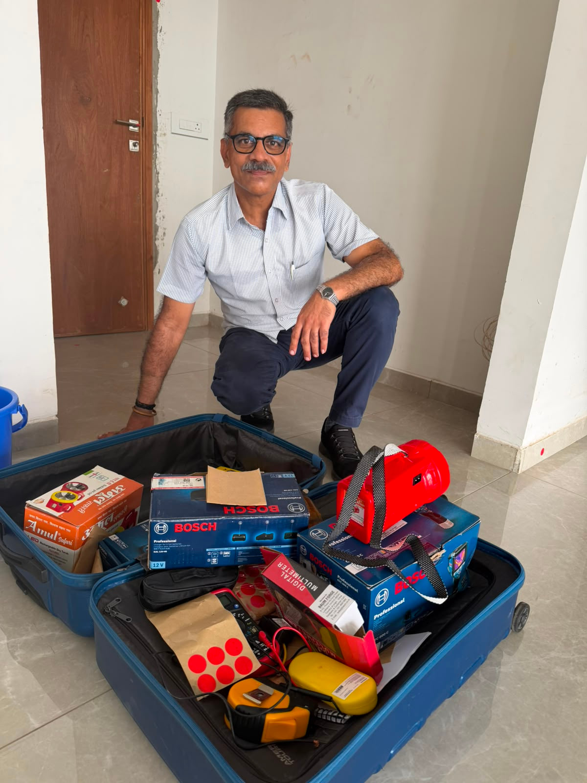 Inspector reviewing property inspection tools beside a wall