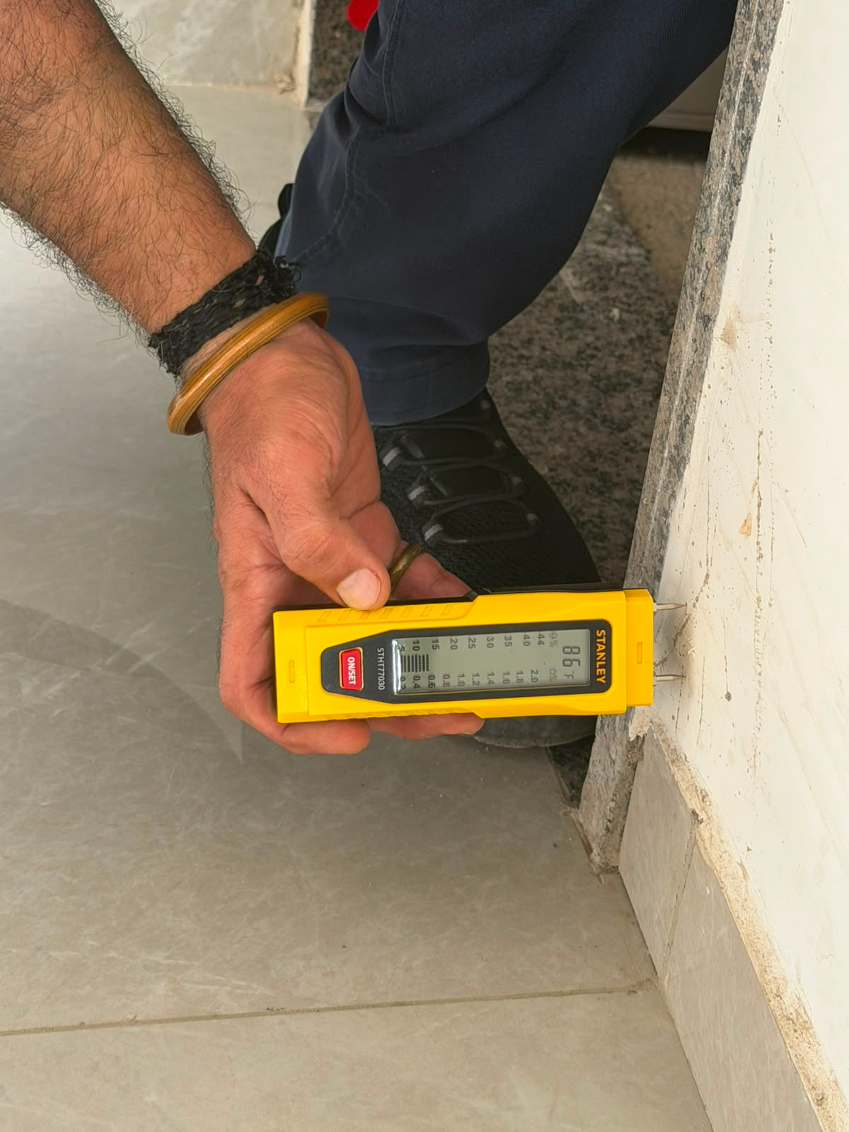 Moisture meter held against an accessible interior wall